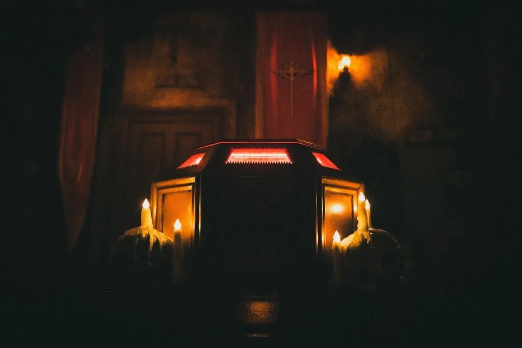 Candles burning on a stone sarcophagus in the Dracula escape room