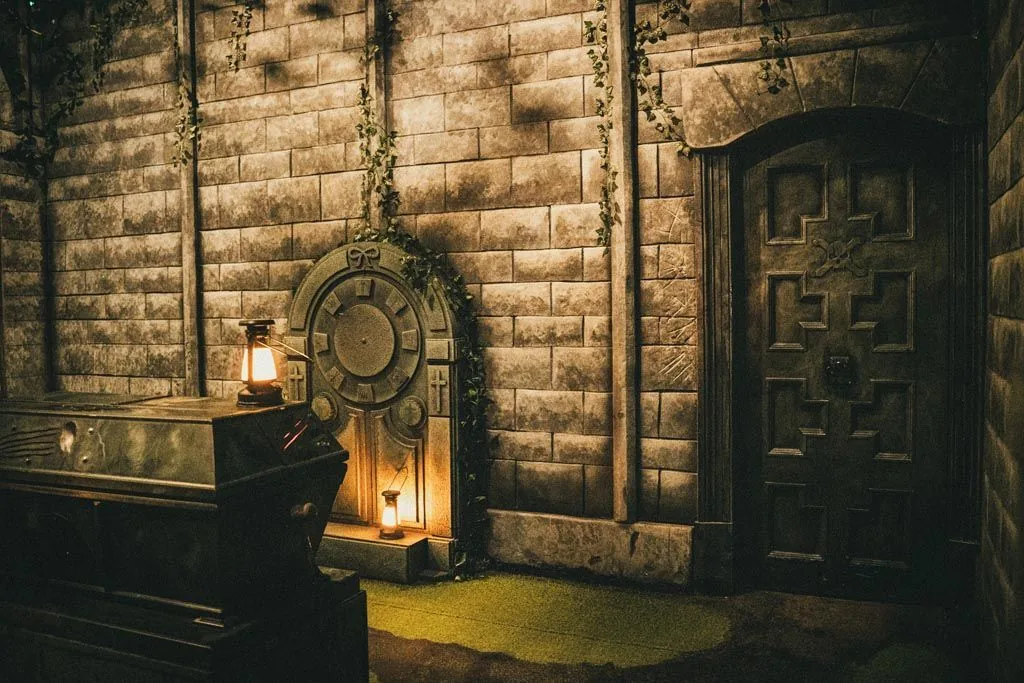 Carved stone crypt doors and a sarcophagus on mossy ground in Dracula