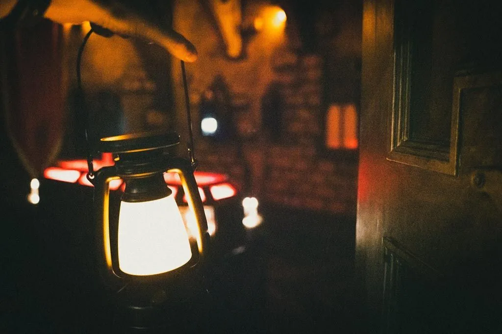 A lantern glowing beside a curtained archway in the Dracula crypt